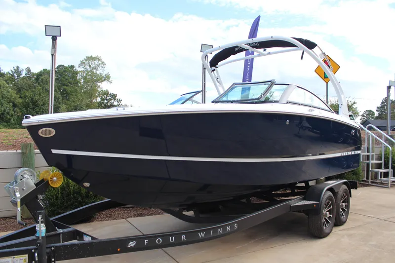 Slide: The Image of 2026 Four Winns H2 Freedom boat on trailer, sleek design, outdoor display. - 7
