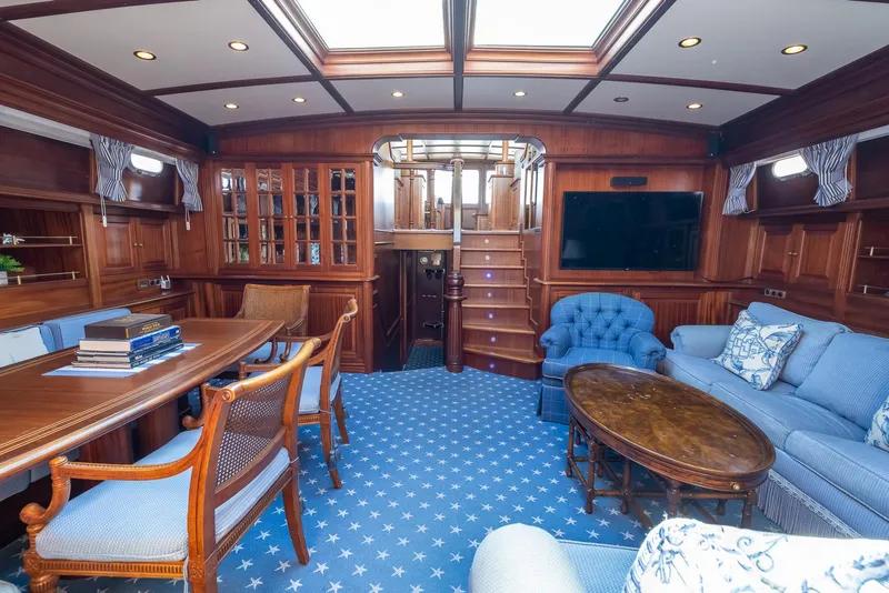 Slide: The Image of Luxurious 2006 Vicem 85 Classic yacht interior with elegant wood paneling and plush blue seating. - 38