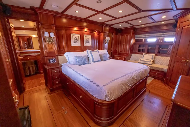 Slide: The Image of Luxurious wood-paneled bedroom in 2006 Vicem 85 Classic yacht, featuring elegant bedding and cozy seating. - 46