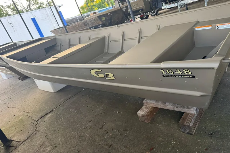 Slide: The Image of 2026 G3 Gator Tough 1436 boat displayed on wooden supports. - 7