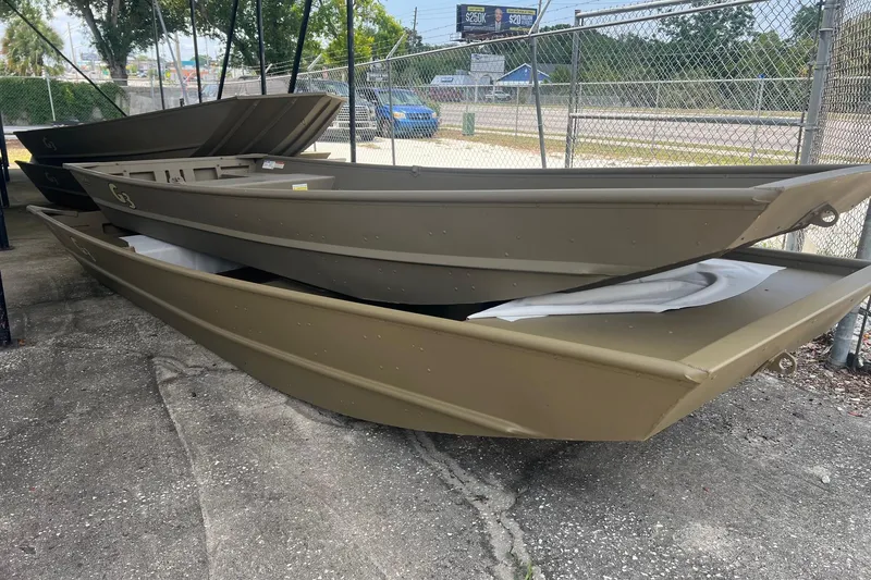 Slide: The Image of 2026 G3 Gator Tough 1436 boats stacked outdoors near a chain-link fence. - 8