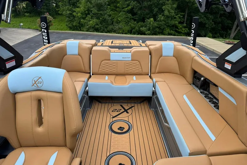 Slide: The Image of 2025 MasterCraft X22 boat interior with tan and blue seating, featuring luxury design elements. - 12