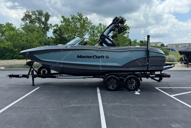 Slide: The Image of 2025 MasterCraft X22 boat on trailer in parking lot, cloudy sky background. - 4
