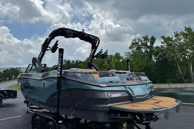 Slide: The Image of 2025 MasterCraft X22 boat with sleek design, parked near a scenic lake. - 5