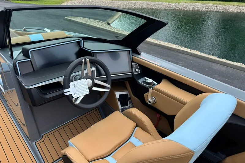 Slide: The Image of 2025 MasterCraft X22 boat interior with modern dashboard and tan leather seating. - 8
