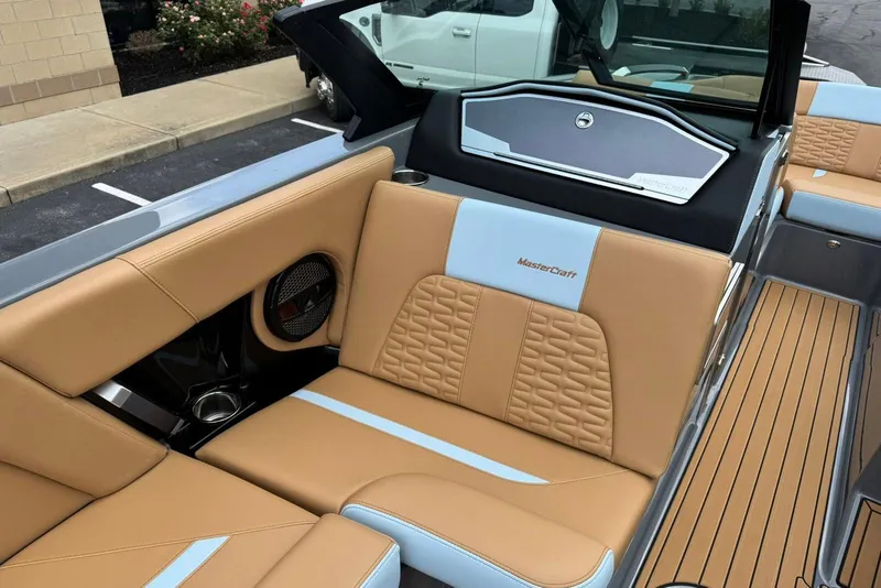 Slide: The Image of 2025 MasterCraft X22 boat interior with tan and blue seating, showcasing luxury design. - 9