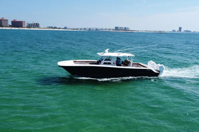 Slide: The Image of 2024 Invincible 46 Catamaran cruising on ocean with city skyline in background. - 10