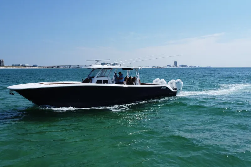 Slide: The Image of 2024 Invincible 46 Catamaran cruising on clear blue waters near a city skyline. - 11