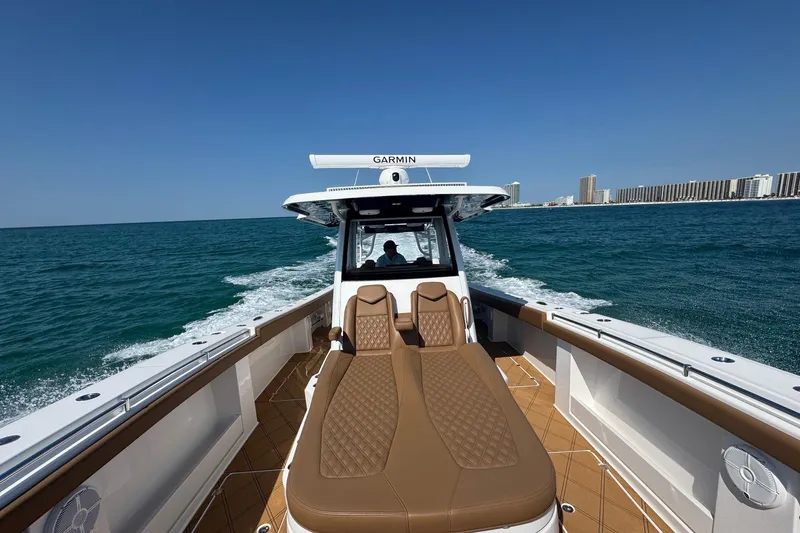 Slide: The Image of 2024 Invincible 46 Catamaran cruising on open water with city skyline in background. - 14