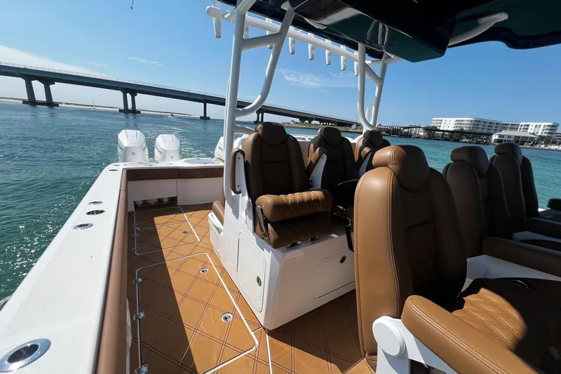 Slide: The Image of 2024 Invincible 46 Catamaran with luxurious seating, cruising near a scenic bridge. - 23