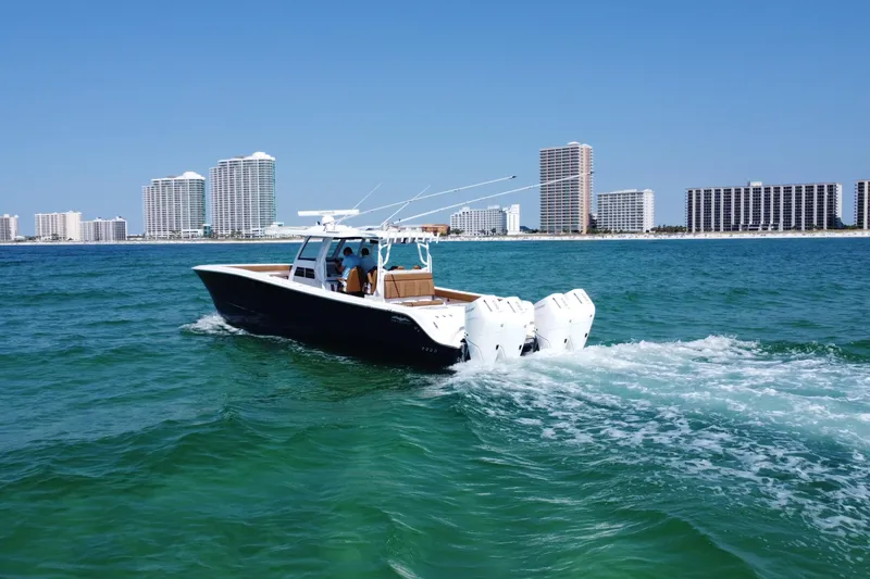 Slide: The Image of 2024 Invincible 46 Catamaran cruising on ocean with city skyline in background. - 25