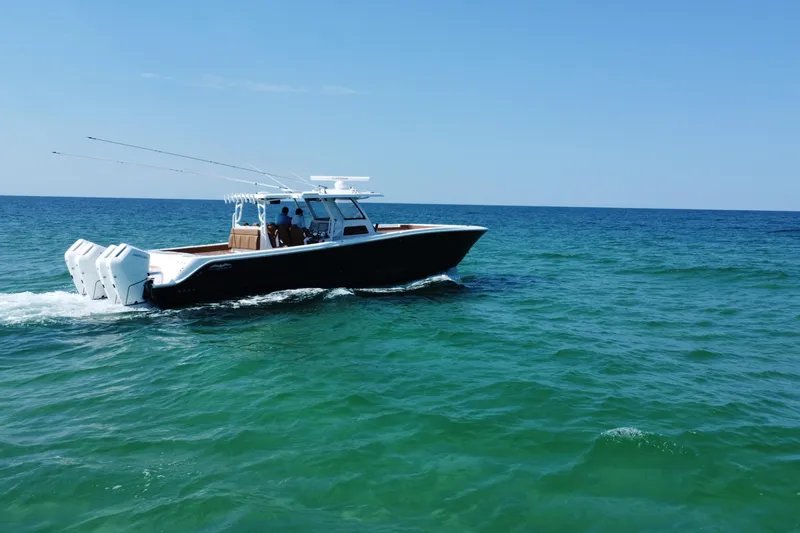 Slide: The Image of 2024 Invincible 46 Catamaran cruising on open sea under clear blue sky. - 26