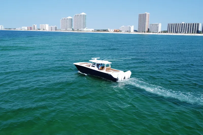 Slide: The Image of 2024 Invincible 46 Catamaran cruising on ocean near city skyline. - 3