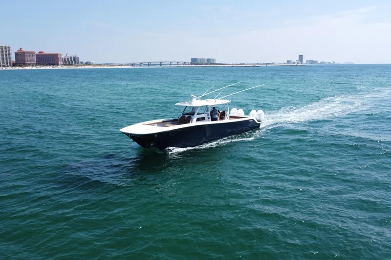 Slide: The Image of 2024 Invincible 46 Catamaran cruising on open water near coastal cityscape. - 30