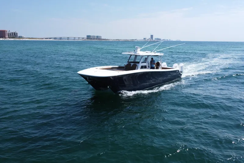 Slide: The Image of 2024 Invincible 46 Catamaran cruising on open water, with distant cityscape background. - 32