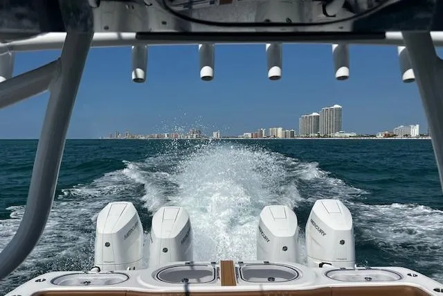 Slide: The Image of 2024 Invincible 46 Catamaran cruising on ocean, city skyline in background. - 49