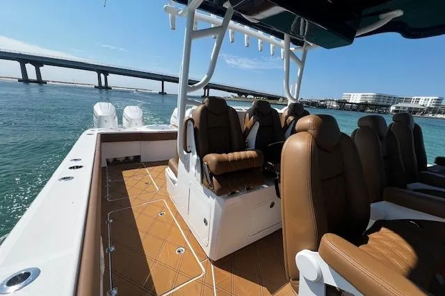 Slide: The Image of 2024 Invincible 46 Catamaran with brown seating, on water near a bridge. - 51