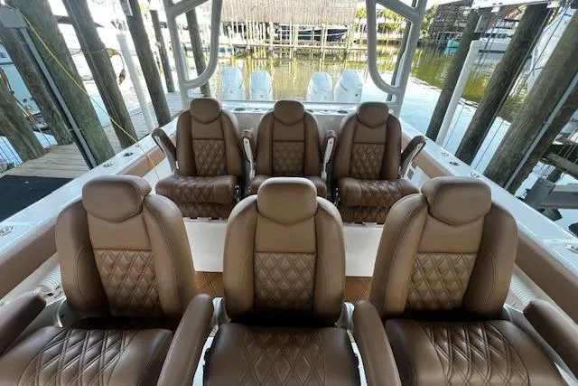 Slide: The Image of 2024 Invincible 46 Catamaran with luxurious brown leather seating, docked at marina. - 54