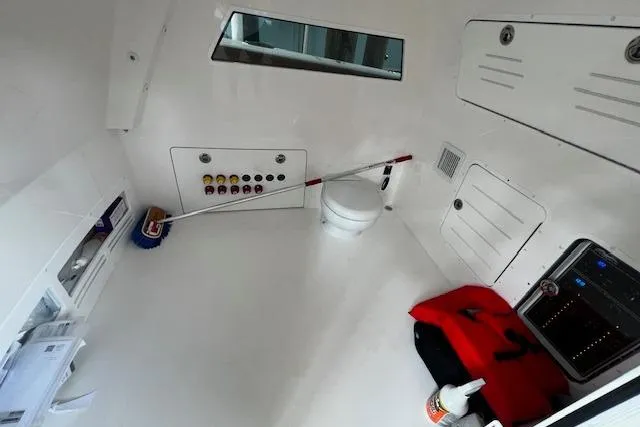 Slide: The Image of 2024 Invincible 46 Catamaran interior with storage, controls, and marine toilet. - 55