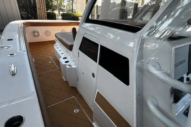 Slide: The Image of 2024 Invincible 46 Catamaran interior with seating, storage, and Garmin equipment. - 59