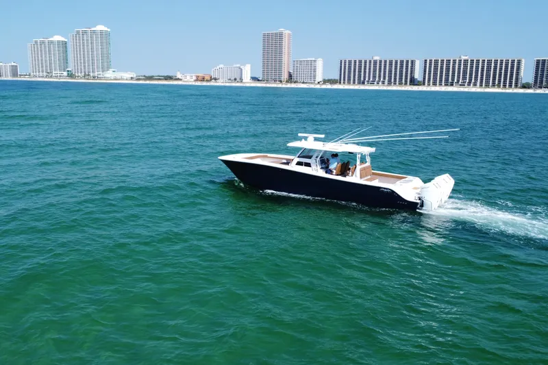 Slide: The Image of 2024 Invincible 46 Catamaran cruising on ocean with city skyline in background. - 6