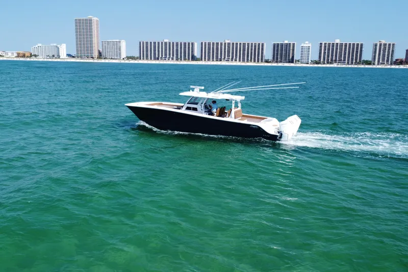 Slide: The Image of 2024 Invincible 46 Catamaran cruising on blue ocean near city skyline. - 7