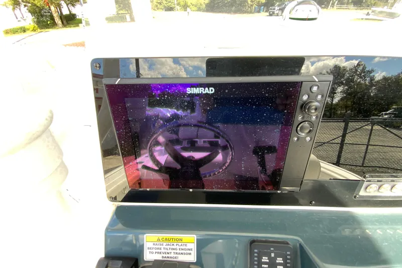 Slide: The Image of Simrad display on 2022 Tidewater 2300 Carolina Bay boat dashboard, reflecting steering wheel. - 13