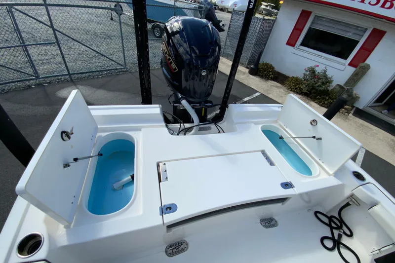 Slide: The Image of 2022 Tidewater 2300 Carolina Bay boat with open storage compartments and outboard motor. - 17