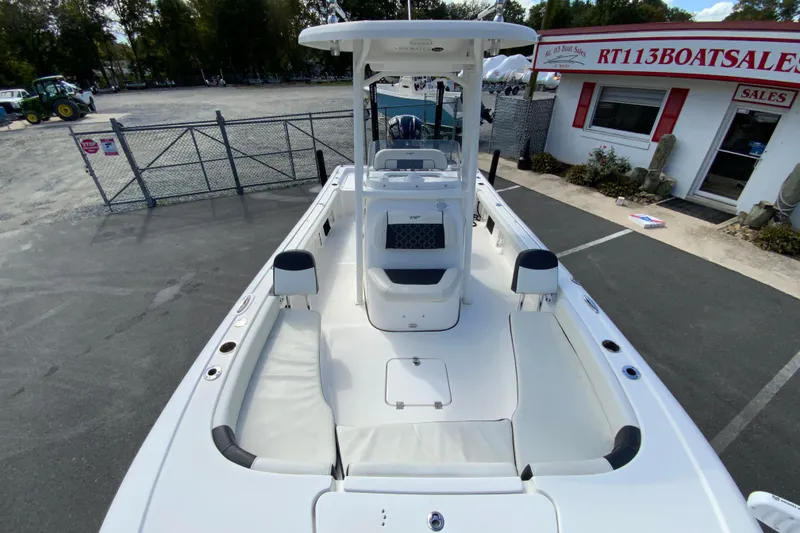 Slide: The Image of 2022 Tidewater 2300 Carolina Bay boat at dealership, showcasing spacious deck and seating. - 25