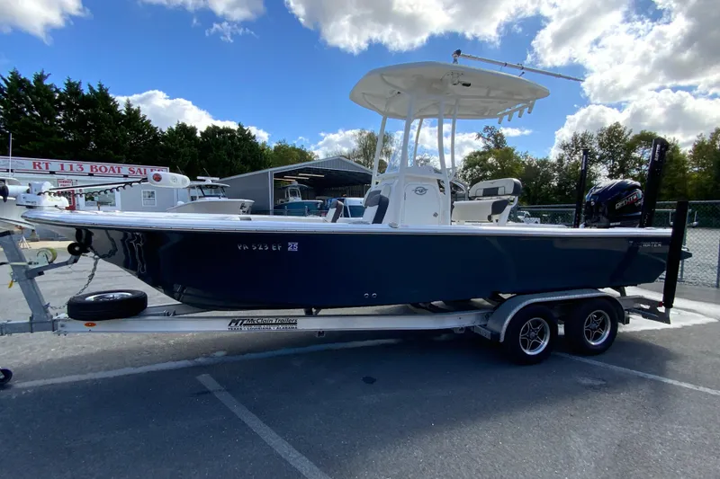 Slide: The Image of 2022 Tidewater 2300 Carolina Bay boat on trailer at dealership under cloudy sky. - 6