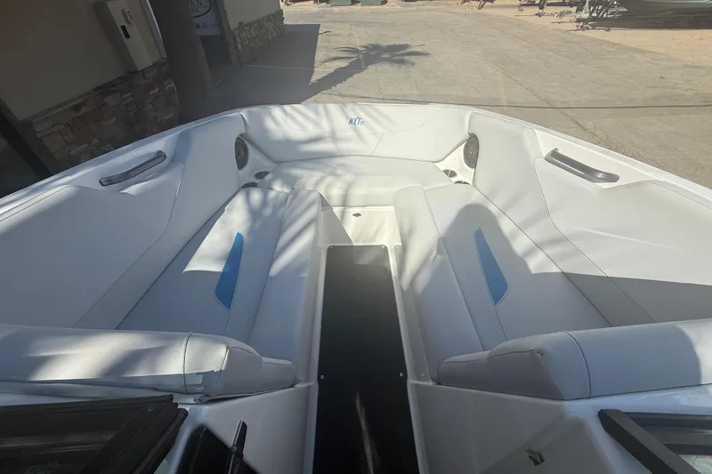 Slide: The Image of 2021 MasterCraft NXT24 boat interior with white seating and blue accents. - 13