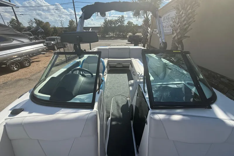 Slide: The Image of 2021 MasterCraft NXT24 boat interior with open windshield, parked outdoors. - 14