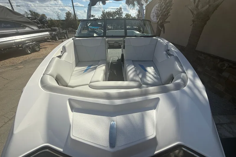 Slide: The Image of 2021 MasterCraft NXT24 boat with white interior seating, parked outdoors. - 3
