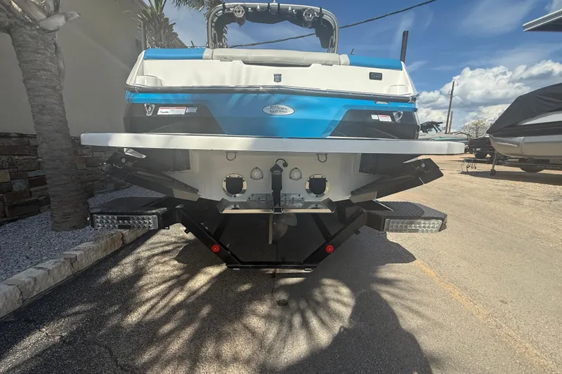 Slide: The Image of 2021 MasterCraft NXT24 boat rear view, showcasing sleek design and vibrant blue accents. - 7