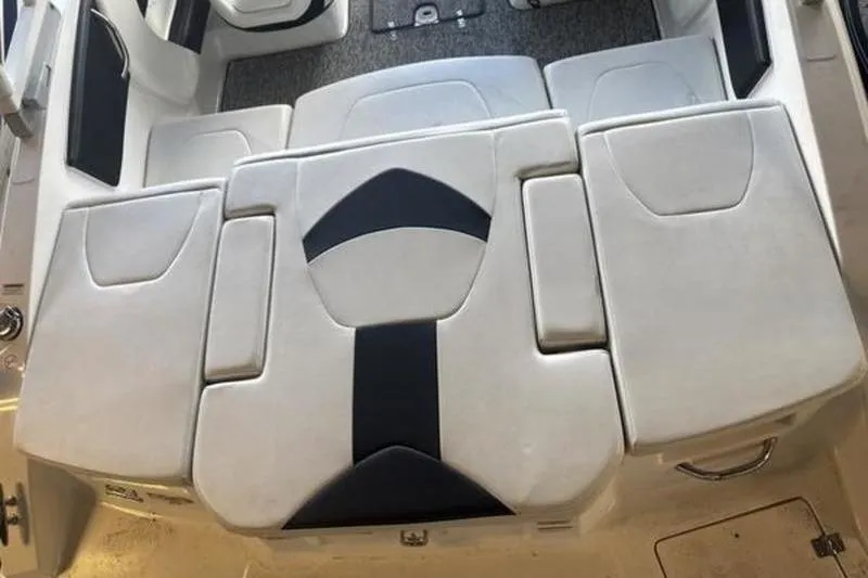 Slide: The Image of 2018 Chaparral 21 H2O Sport boat interior seating, featuring white and black upholstery. - 17