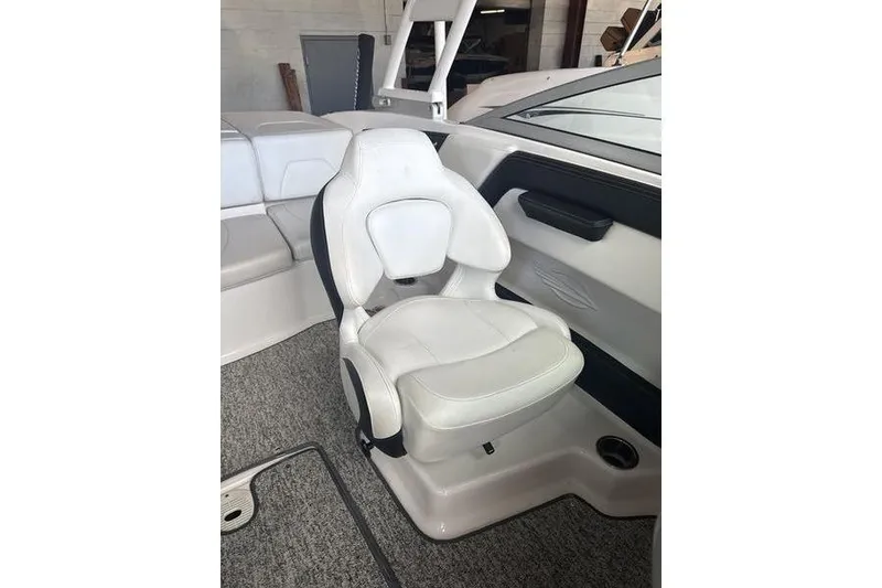 Slide: The Image of 2018 Chaparral 21 H2O Sport boat interior with white captain's seat and gray carpet. - 7