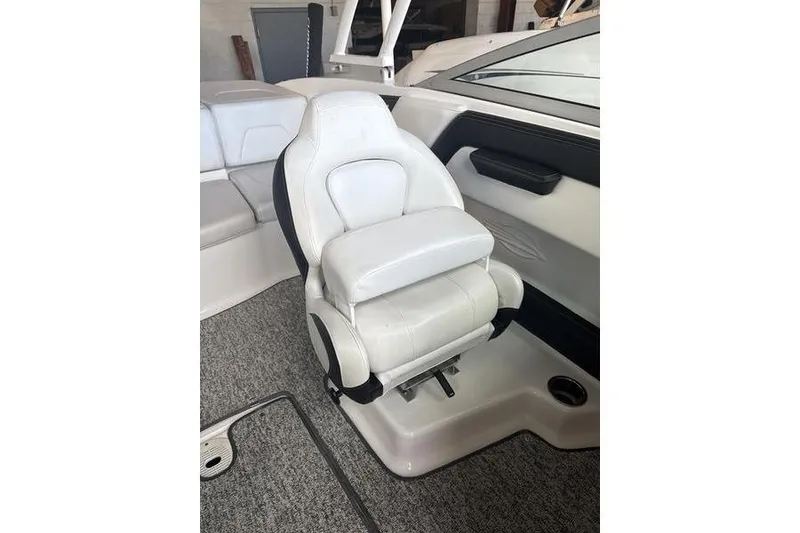 Slide: The Image of 2018 Chaparral 21 H2O Sport boat interior with white captain's seat and gray carpet. - 8