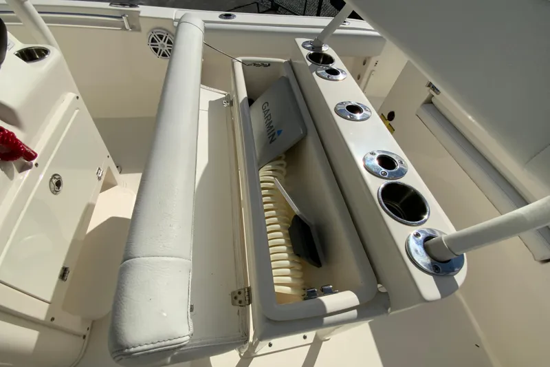 Slide: The Image of 2021 Cobia 220 Center Console boat interior with rod holders and storage compartment. - 18