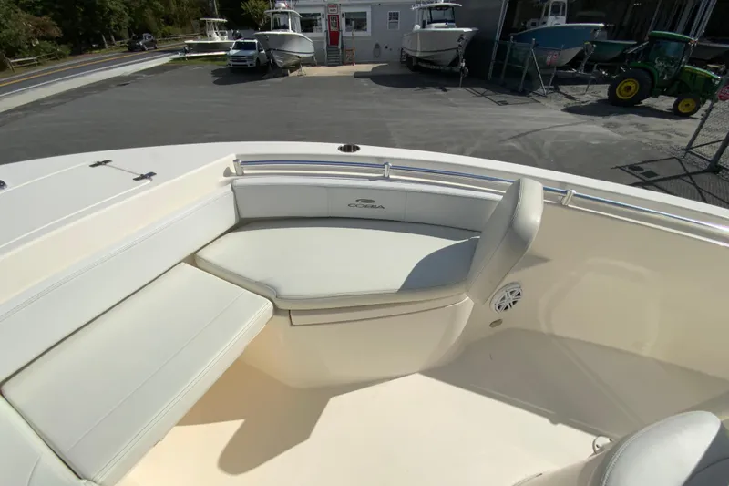 Slide: The Image of 2021 Cobia 220 Center Console boat with cushioned seating in a marina setting. - 27