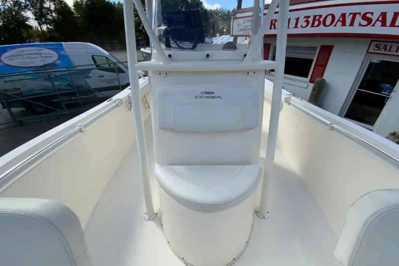 Slide: The Image of 2021 Cobia 220 Center Console boat interior at dealership, featuring seating and console. - 31