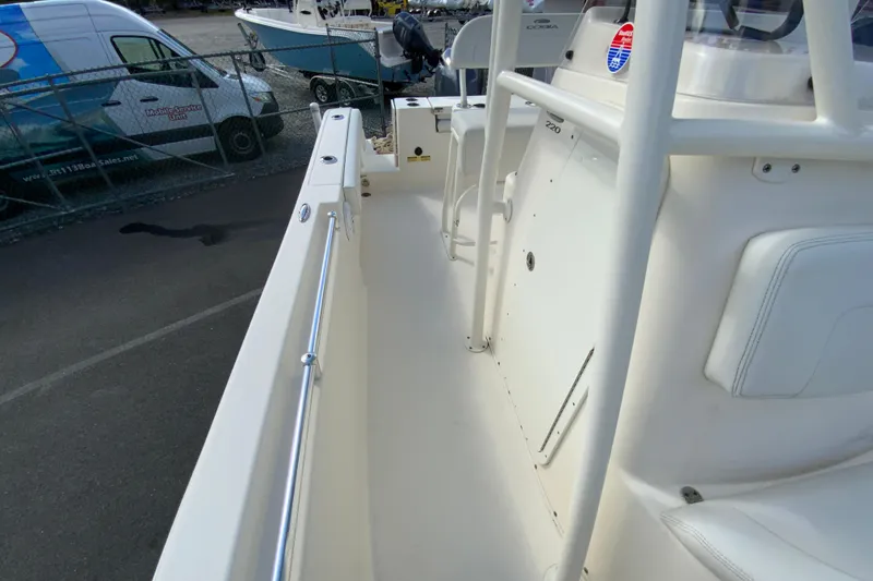 Slide: The Image of 2021 Cobia 220 Center Console boat interior with white seating and railing. - 33