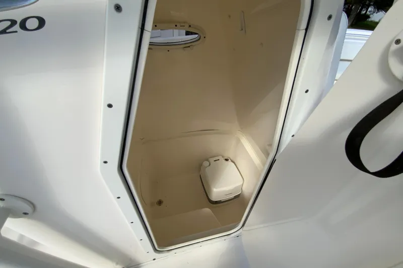Slide: The Image of 2021 Cobia 220 Center Console boat interior with compact marine toilet. - 34