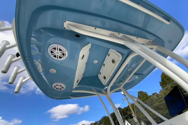 Slide: The Image of 2021 Cobia 220 Center Console boat's underside view with speakers and rod holders. - 35