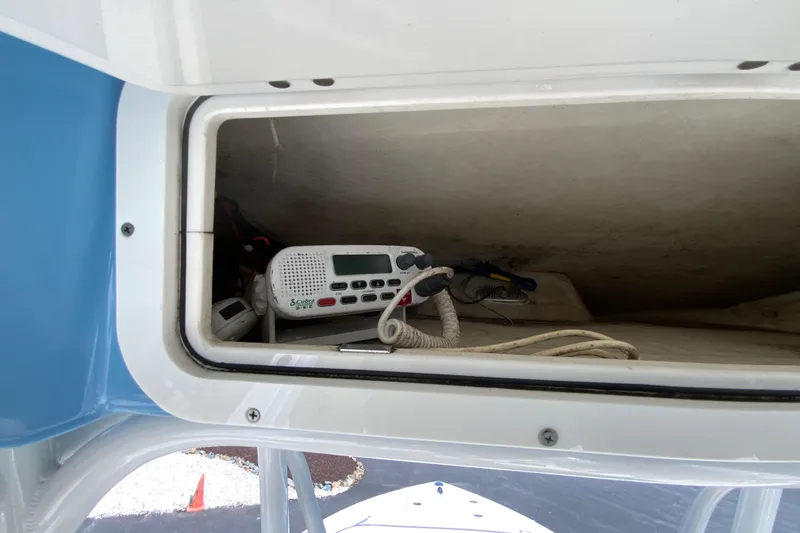 Slide: The Image of Storage compartment with radio equipment on 2021 Cobia 220 Center Console boat. - 36