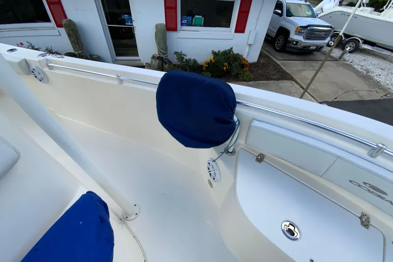 Slide: The Image of 2021 Cobia 220 Center Console boat interior with blue seat covers and stainless steel railings. - 37