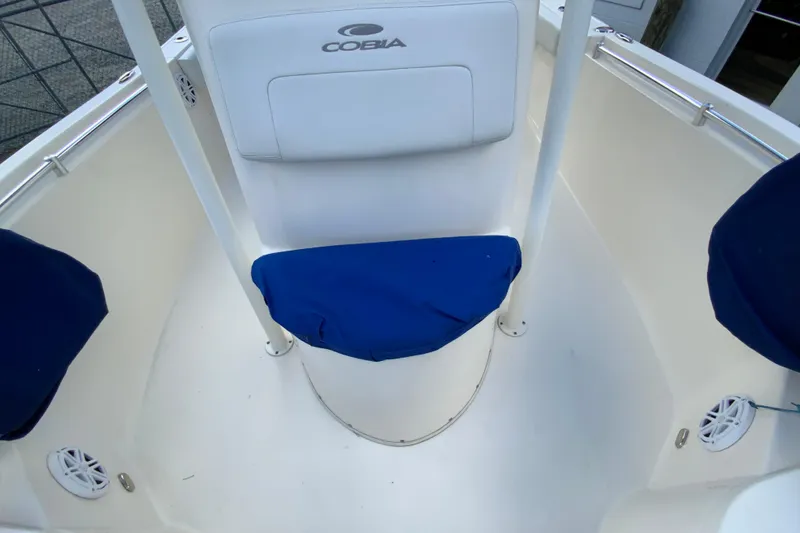 Slide: The Image of 2021 Cobia 220 Center Console boat interior with blue seat covers and white console. - 38