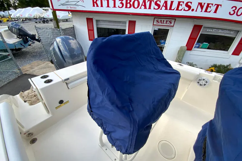 Slide: The Image of 2021 Cobia 220 Center Console boat at dealership with covered seats. - 40