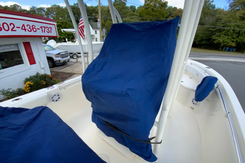 Slide: The Image of 2021 Cobia 220 Center Console boat with blue seat covers, parked near a sales office. - 41
