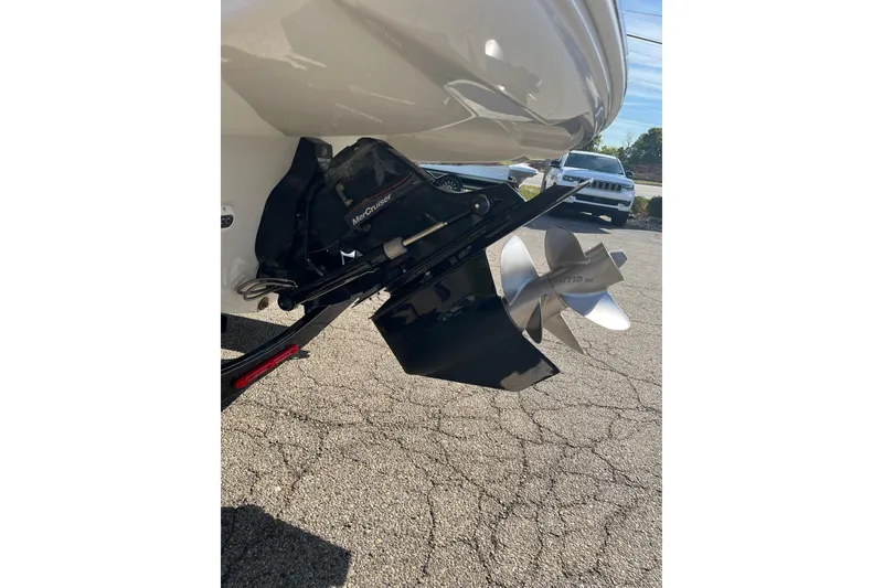 Slide: The Image of 2021 Crownline 290 SS boat with MerCruiser outdrive and propeller, parked on pavement. - 18