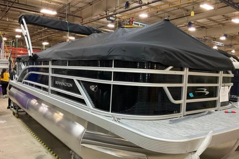 Slide: The Image of 2026 Bennington 22 SSRSF pontoon boat with black cover in a factory setting. - 10
